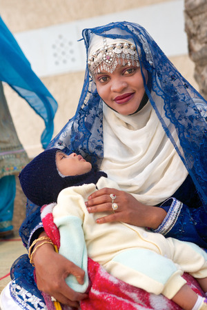 MUSCAT, OMAN - FEBRUARY 1, 2008  An Omani mother in  traditional dress with her baby in Muscat, in the Sultanate of Oman のeditorial素材