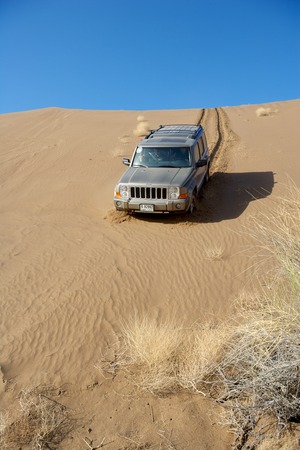A Dubai-registered Jeep Commander 4x4 vehicle negotiates a steep dune while driving offroad in the interior of the Sultanate of Oman.のeditorial素材