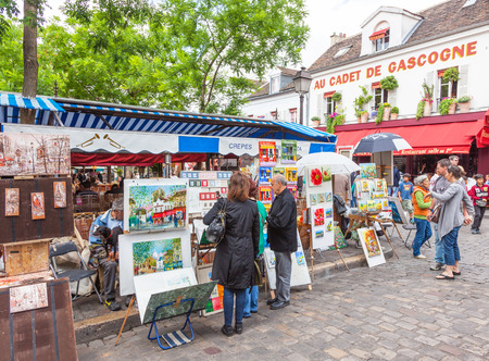 Tourists viewing art for sale at outdoor stalls in Montmartre in Paris.のeditorial素材
