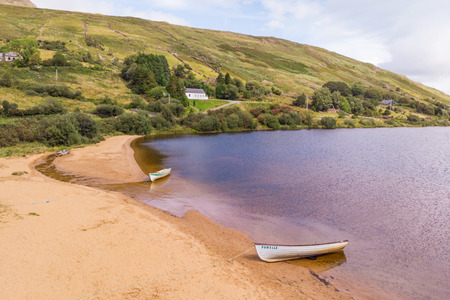 LOUGH NAFOOEY, IRELAND - AUGUST 21, 2018: An aerial view of two boats on the beach at scenic Lough Nafooey in the Connemara region of Ireland.のeditorial素材