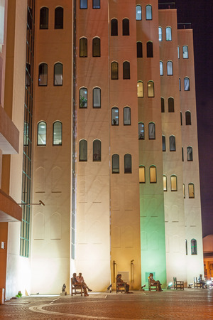 DUBAI, UAE - MAY 17, 2011: Residents relaxing in the cool night air outside a colorful building overlooking Dubai Creek in Dubai, UAE.のeditorial素材