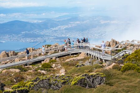 TASMANIA, AUSTRALIA - FEBRUARY 16, 2019: Tourists on a boardwalk on top of Mount Wellington, looking...