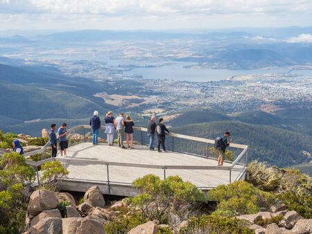 TASMANIA, AUSTRALIA - FEBRUARY 16, 2019: Tourists on a viewing platform on top of Mount Wellington, looking at Hobart, the capital city of Tasmania in Australia.のeditorial素材
