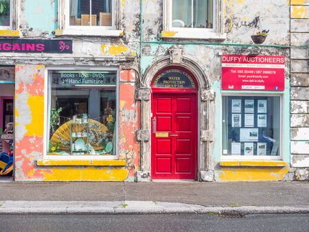 HEADFORD, IRELAND - AUGUST 6, 2019: Dilapidated but colorful shops and offices situated in Main...