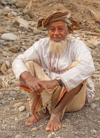 RURAL INTERIOR, OMAN - FEBRUARY 1, 2008: An Omani farmer, wearing a muzzar (traditional woollen turban), relaxes in a wadi below his date plantation in the rural interior of Oman.のeditorial素材