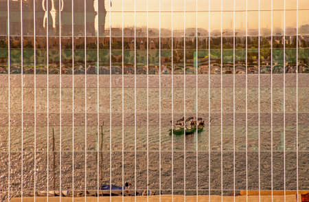 A late-afternoon reflection on the window of a modern building of an abra - a traditional water taxi...