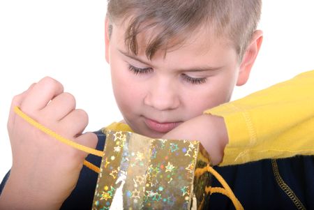 Boy searches for a gift in a bag on a white backgroundの写真素材