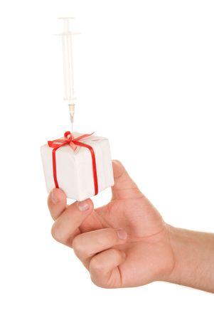 Hand holds gift with the thrust syringe on white backgroundの写真素材