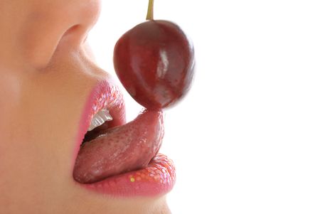 Woman with make-up licks cherry isolated in whiteの写真素材