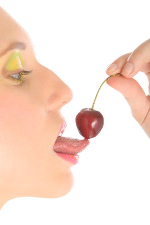 Woman with make-up licks cherry isolated in whiteの写真素材