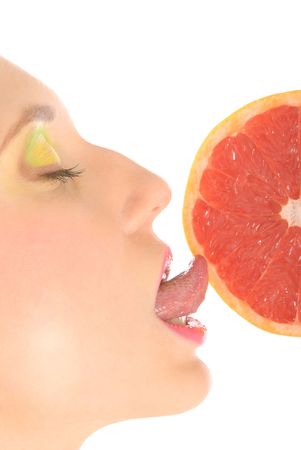 Woman with make-up licks grapefruit isolated in whiteの写真素材