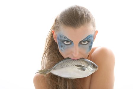 Woman in make-up with fish in mouth isolated in whiteの写真素材