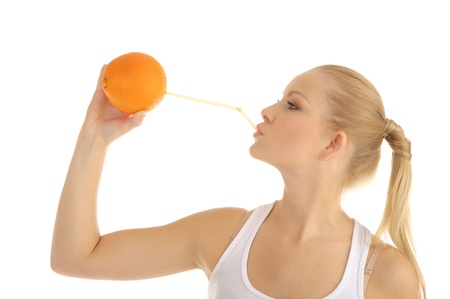 woman drinking orange juice through a strawの写真素材