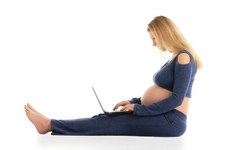 pregnant woman with a laptop sitting on the floorの写真素材