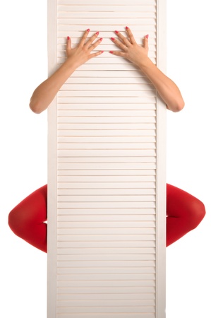 Female feet in red stockings, hands and doorの写真素材