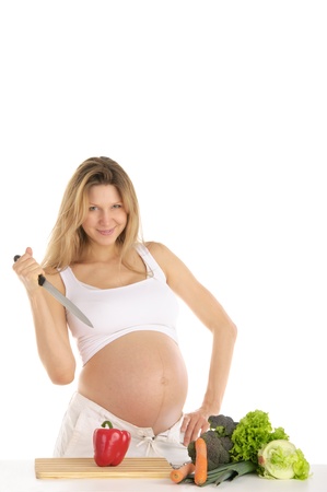 pregnant woman with fruits, vegetables and knifeの写真素材