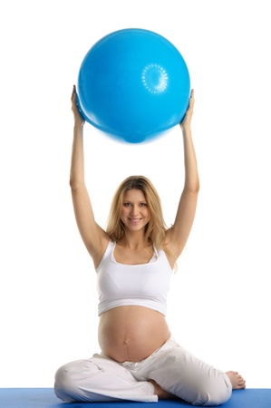 Pregnant woman practicing yoga with ballの写真素材