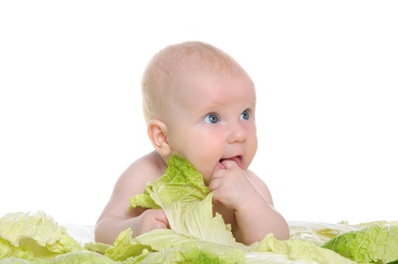 small child sitting among the cabbage leavesの写真素材