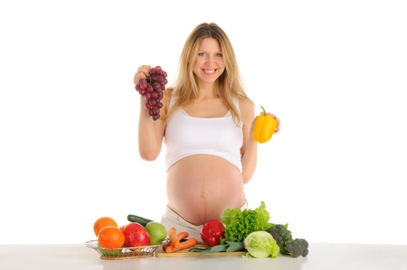 Happy pregnant woman with fruits and vegetables isolated on whiteの写真素材