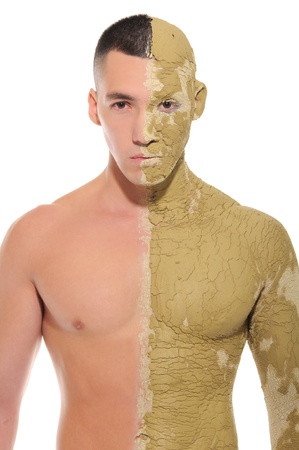 young man half smeared with clay isolated on whiteの写真素材