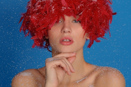 woman with red feathers in the snowの写真素材