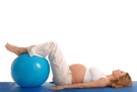 pregnant woman practicing yoga with blue ballの写真素材