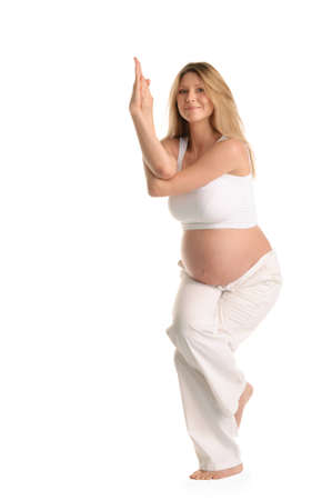Pregnant woman standing and practicing yoga isolated on whiteの写真素材