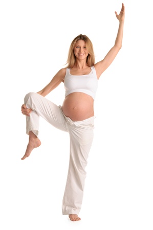 Pregnant woman standing and practicing yoga isolated on whiteの写真素材