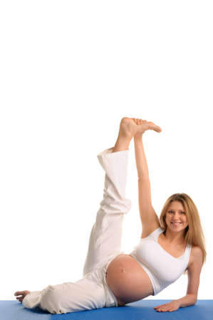 pregnant woman lying down and practicing yoga on isolated whiteの写真素材