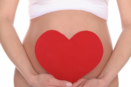 pregnant woman holding red heartの写真素材