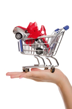Cars and gift ribbon in shopping trolley on palmの写真素材