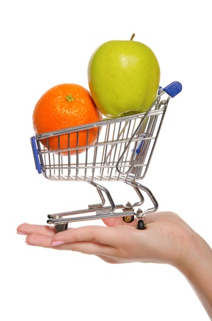 orange and apple in shopping trolley on the palmの写真素材