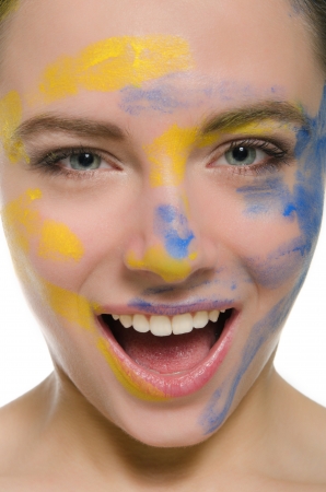 smiling woman with paint on his faceの写真素材