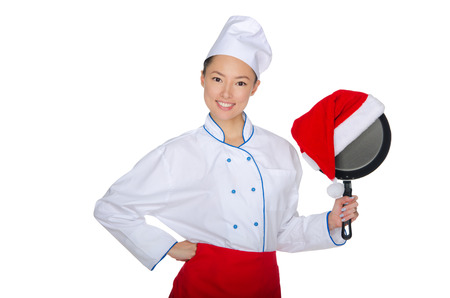 Asian chef and a frying pan in Santa hat isolated on whiteの写真素材