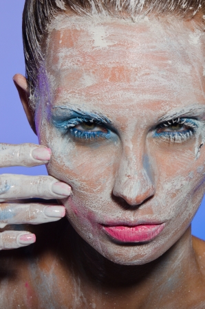 Vertical portrait of young woman with paint on his faceの写真素材