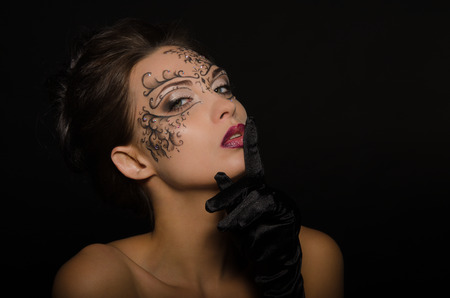 Beautiful woman with openwork ornament isolated on blackの写真素材