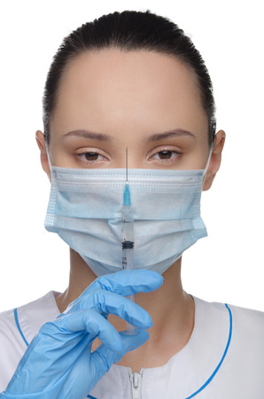 Doctor in a mask and syringe isolated on whiteの写真素材