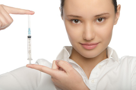 Young woman shows a syringe with a needleの写真素材