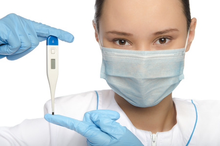 Young doctor in mask, gloves and thermometer isolated on whiteの写真素材