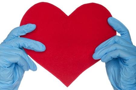 Two hands in blue medical gloves and heart on white の写真素材