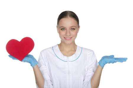 Smiling female doctor weighs on hand red heart symbolの写真素材