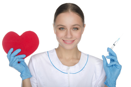 Smiling doctor shows a red heart symbol and syringeの写真素材