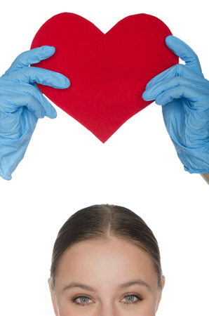 Woman held up a red heart symbolの写真素材