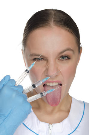 Predatory doctor holding three syringe isolated on whiteの写真素材