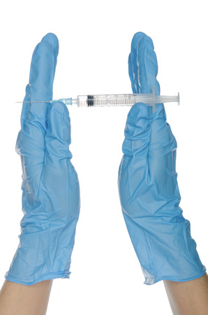 Hands in blue gloves demonstrate a syringe with a vaccineの写真素材