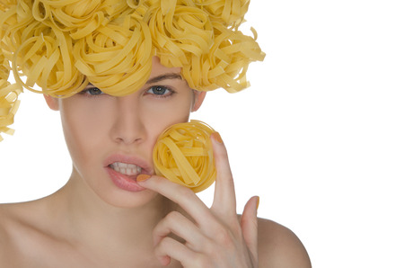 Nude young woman with fancy curls of pastaの写真素材