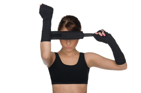 Athletic young woman pulls black boxing bandagesの写真素材