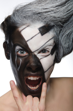 Portrait with musical makeup and rock gesture isolated on whiteの写真素材
