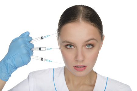 Doctor in gloves holding the syringe in his hand in front of their faceの写真素材