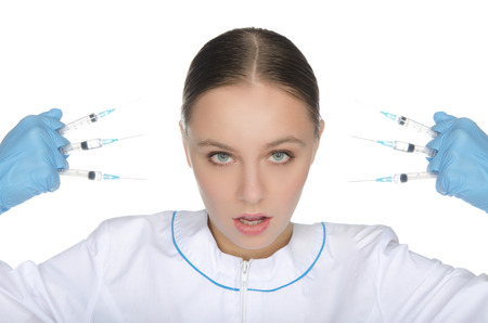 Doctor in holding syringe in his hands front of faceの写真素材